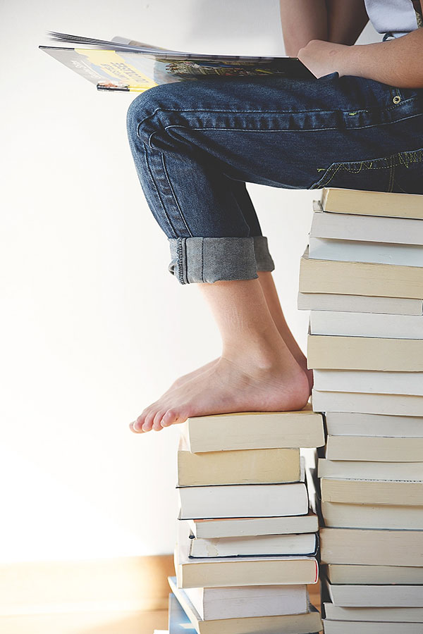Podología - Pies descalzos sobre libros